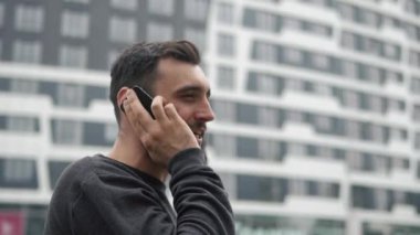 Şehirde yürüyüş onun Smartphone adam görüşmeler