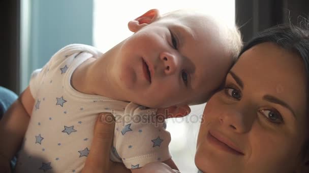 L'enfant se penche sur les mères face assise dans les bras du père — Video