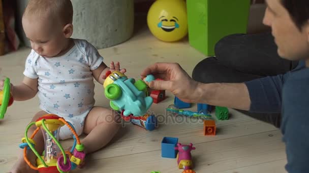 Padre juega con un niño pequeño en el suelo — Vídeo de stock