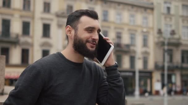 Man talks on the tablet standing somewhere in the city — Stock Video