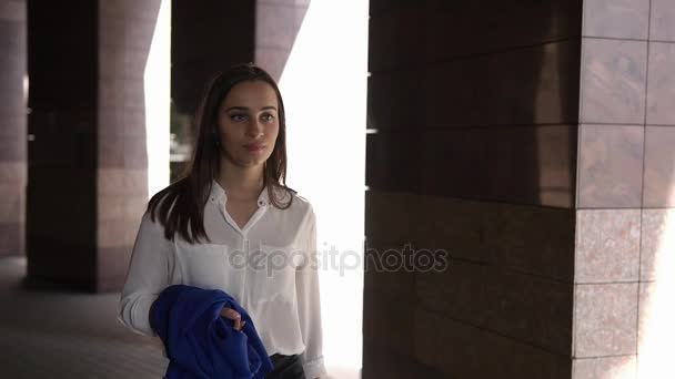 Mujer camina con traje azul en su brazo — Vídeos de Stock