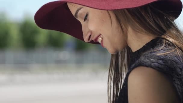 Улыбающаяся женщина в красной шляпе читает что-то на планшете — стоковое видео