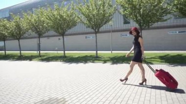 Kırmızı çanta dışında kırmızı şapkalı kadın yürüyor