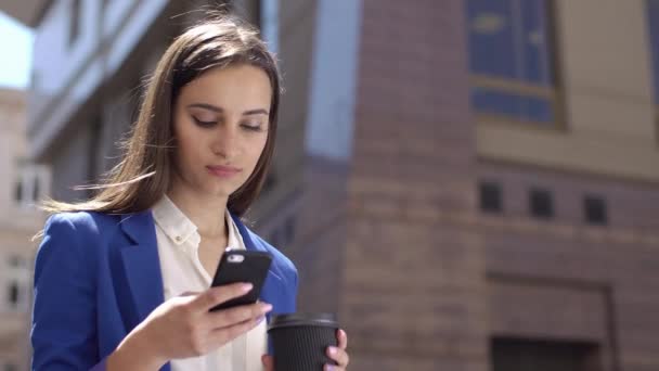 Biznes kobieta sprawdza jej telefon stojący w mieście — Wideo stockowe