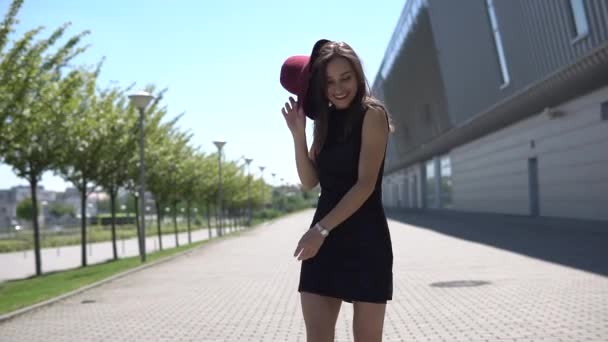 Pretty woman poses in red hat outside in a sunny day — Stock Video