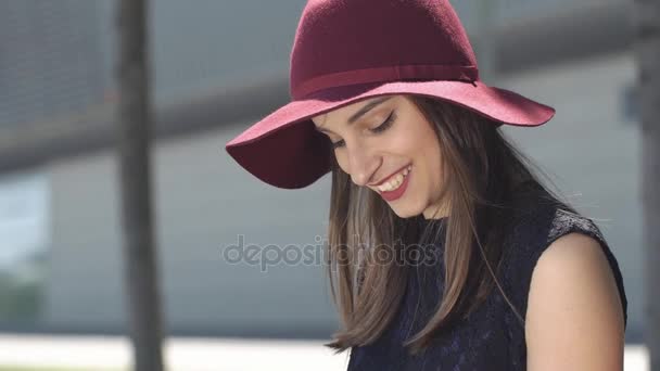 Mulher sorridente de chapéu vermelho lê algo em seu tablet — Vídeo de Stock