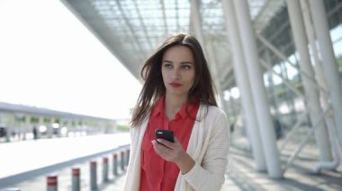 Kadın kırmızı gömlek görüşmelerde bir bavulla yürümek telefon