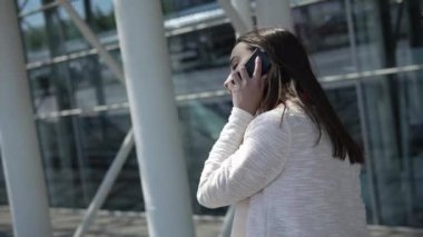 Kadın kırmızı gömlek görüşmelerde bir bavulla yürümek telefon