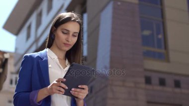 İş kadını tablet ayakta şehrin üzerinde bir şey okur