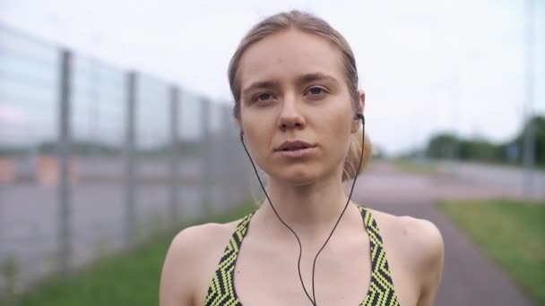 Correr mujer escucha la música en el camino — Vídeo de stock