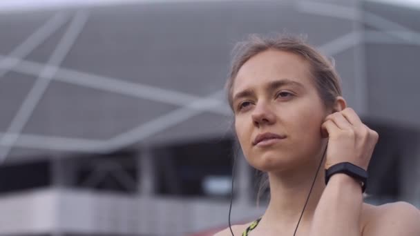 Correr mujer enciende la música en su teléfono — Vídeo de stock