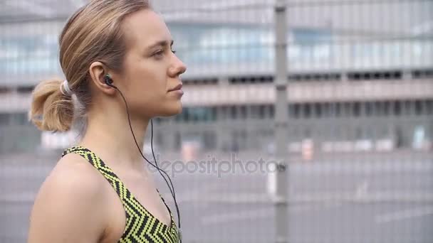 Joggen vrouw luistert naar de muziek op de manier — Stockvideo