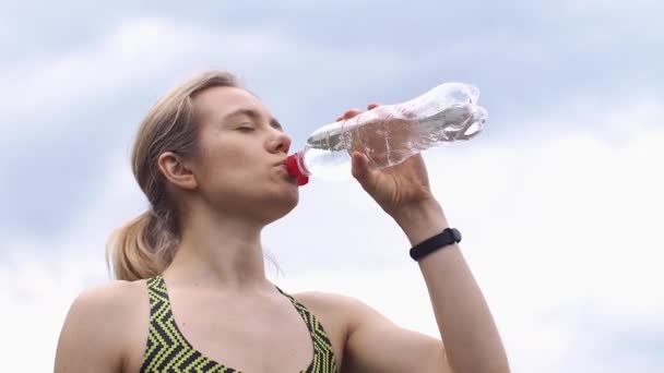 Mujer en traje de correr bebe agua — Vídeo de stock