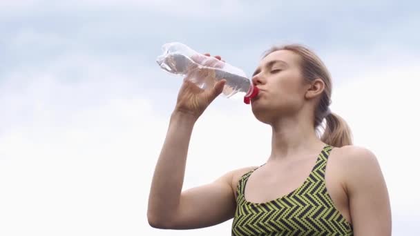 Mujer en traje de correr bebe agua — Vídeos de Stock