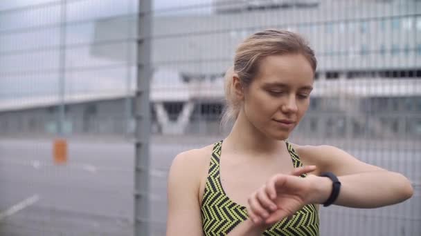 Joggen vrouw controleert haar draagbare apparaat — Stockvideo