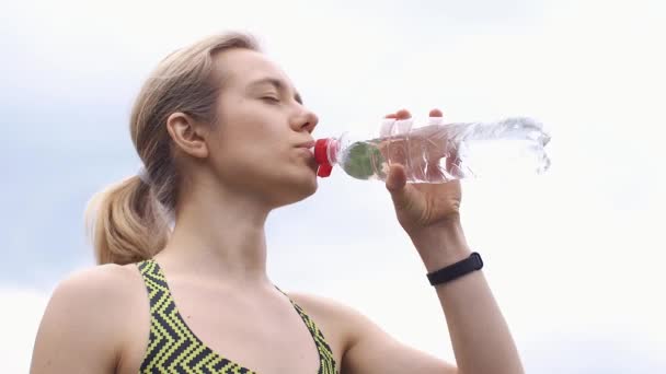Жінка в біговому костюмі п'є воду — стокове відео