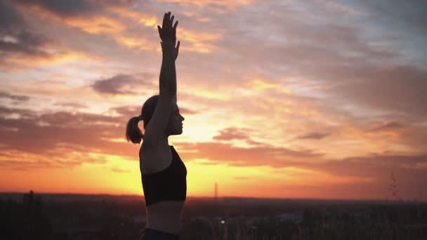 Silueta de una mujer practicando yoga al amanecer — Vídeo de stock