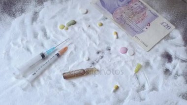 Kokain ve masanın üzerinde yatan hapları üzerinde dolar kalmaktadır