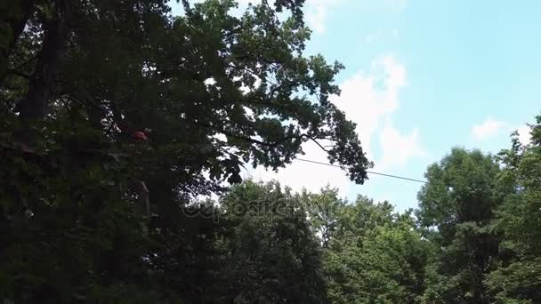 Man goes down on the rope in the entertainment park — Stock Video