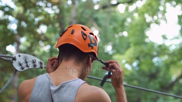 El hombre se prepara para el entretenimiento en el parque de cuerdas — Vídeos de Stock