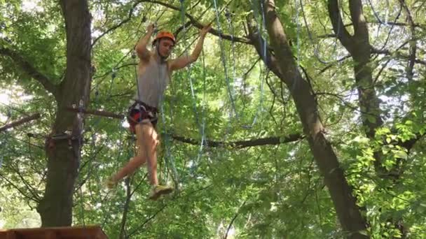 Man climbs on the ropes in entertainment park — Stock Video