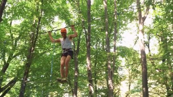 Homme grimpe sur les cordes dans le parc de divertissement 
