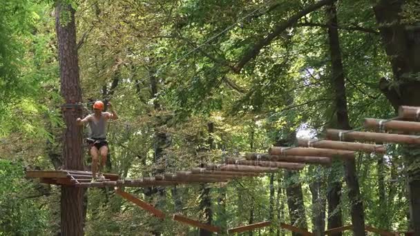 Man climbs on the ropes in entertainment park — Stock Video