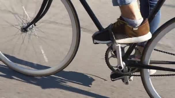 Молодий чоловік їде на велосипеді вздовж вулиці — стокове відео