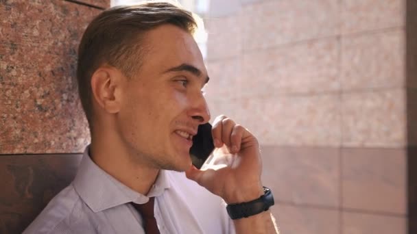 Mladý muž kontroluje jeho telefon stojící na ulici — Stock video