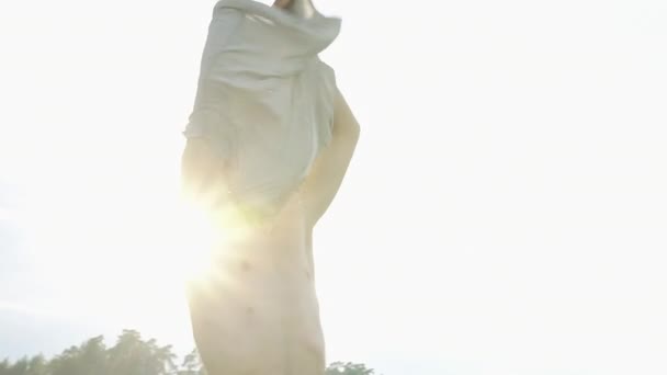 Man neemt uit zijn clouthes staande voor het meer — Stockvideo