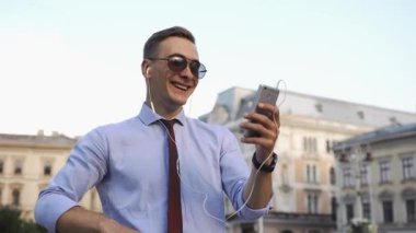 Genç adam onun telefon ayakta sokakta denetler