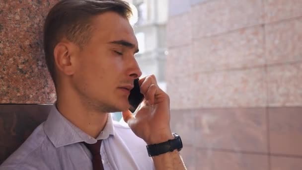 Il ragazzo controlla il suo telefono in piedi sulla strada — Video Stock