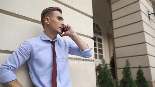 Junger Mann telefoniert auf der Straße stehend — Stockvideo