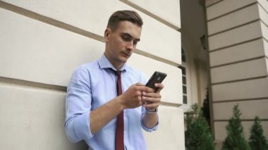 Genç adam onun telefon ayakta sokakta denetler