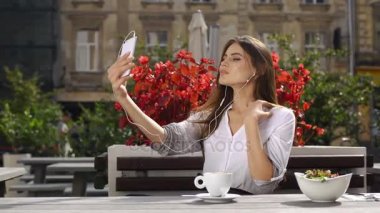 Onu telefona o kırmızı çiçekler önce restoranda otururken kulaklık ile esmer Bayan görüşmeler