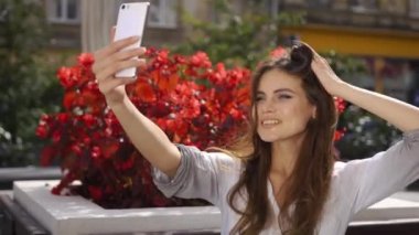 Çarpıcı esmer selfie kırmızı çiçekler önce restoranda oturan telefonu alır