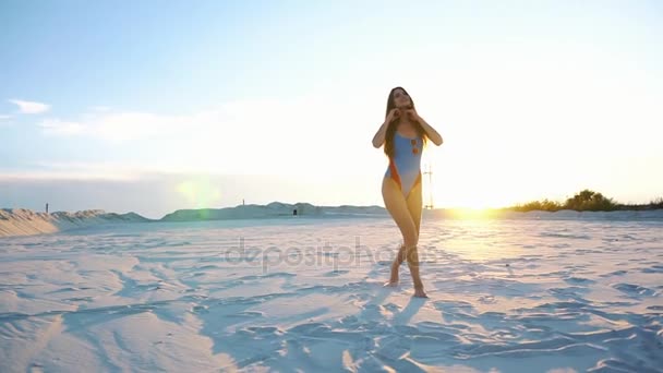 Atemberaubende brünette Frau mit langen Haaren tanzt im Abendlicht am Strand — Stockvideo