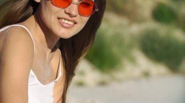 Kırmızı güneş gözlüğü baştan çıkarıcı esmer kum ile sahilde çalış.