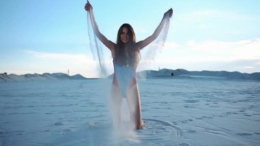 Uzun saçlı esmer kadın beyaz kum ile çalış