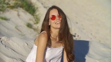 Kırmızı güneş gözlüğü baştan çıkarıcı esmer kum ile sahilde çalış.