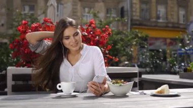 Onu telefona o kırmızı çiçekler önce restoranda otururken kulaklık ile esmer Bayan görüşmeler