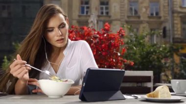 Esmer Bayan salata yiyor ve o kırmızı çiçekler önce restoranda otururken bir şey onun tablet üzerinde saatler