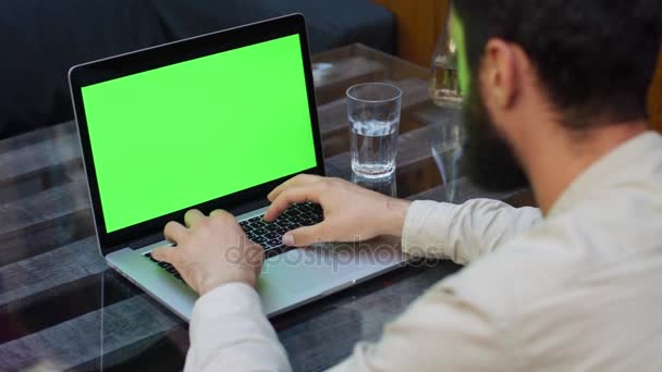 Ο άνθρωπος που εργάζεται για το φορητό υπολογιστή με πράσινη οθόνη — Αρχείο Βίντεο