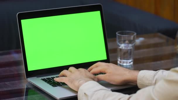 Man fungerar på den bärbara datorn med grön skärm — Stockvideo