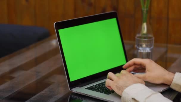 Человек работает на ноутбуке с зеленым экраном — стоковое видео