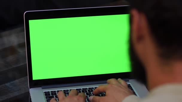 Man fungerar på den bärbara datorn med grön skärm — Stockvideo