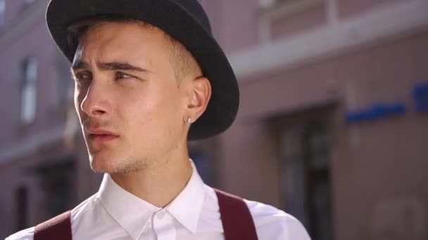 Молодий чоловік знімає капелюх, щоб полагодити своє світле волосся — стокове відео