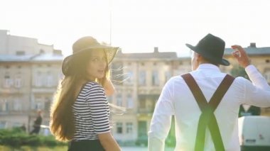 Sevimli erkek ve kadın siyah şapka sunset bulvarında cadde boyunca yürümek