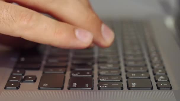 Hombre escribe algo en el teclado negro — Vídeos de Stock