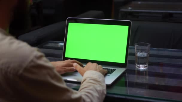 Man works on the laptop with green screen — Stock Video